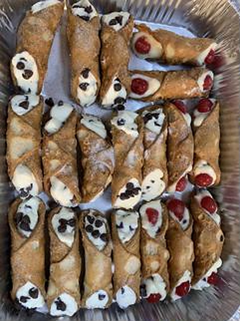 Tray of fresh homemade cannoli with chocolate chip and raspberry
